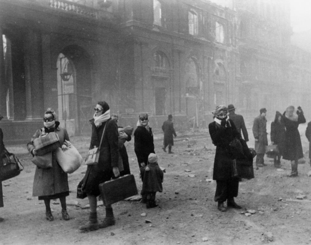 People outside carrying belongings