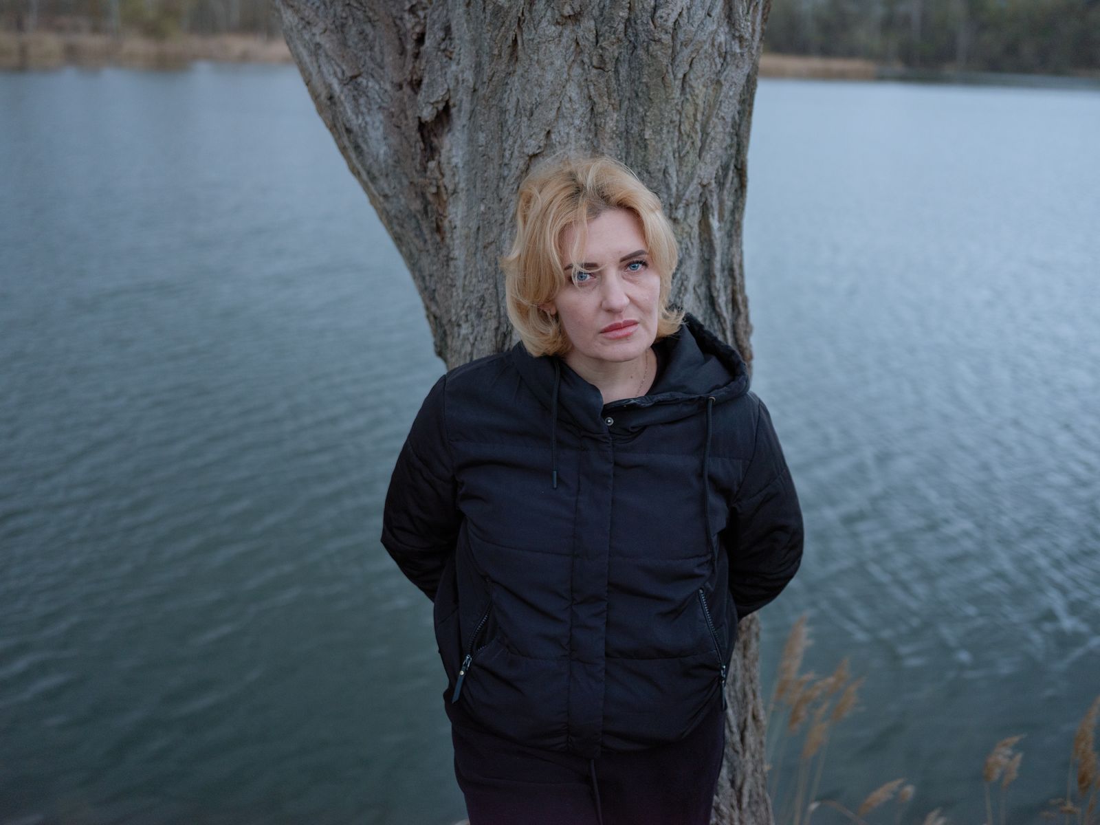A person standing in front of a tree.